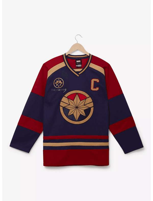 Shop it <a href=https://www.boxlunch.com/product/marvel-the-marvels-carol-danvers-hockey-jersey---boxlunch-exclusive/20560904.html>here</a>